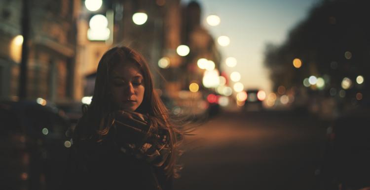 Young woman alone on a street in the dark 