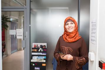 woman wearing a headscarf holding her mobile phone